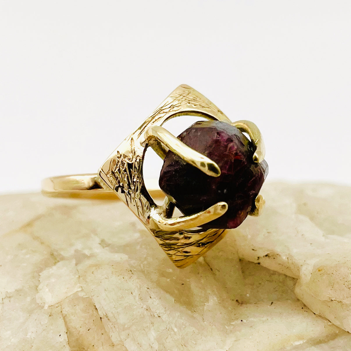 The Expanded Skies Heaven and Earth Raw Garnet Ring has a beautiful raw Norwegian garnet set in 9ct gold. The garnet is set in a distinctive completely handcrafted engraved claw setting. This is a unique piece, one-of-a-kind. Handcrafted on the edge of Dartmoor and made from high quality recycled gold, Hallmarked by the London Assay Office.