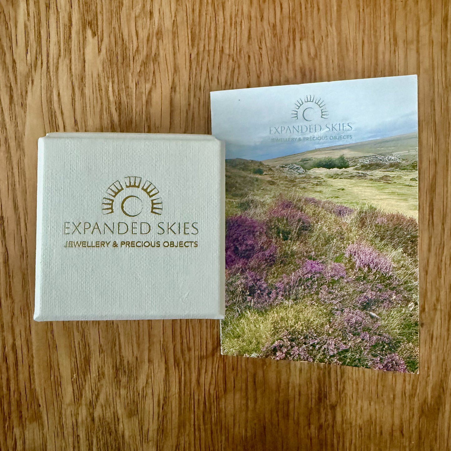 Expanded Skies packaging, a beautiful presentation box, handcrafted in Cornwall with recycled board and textured paper. The interior of the box is lined with natural felt from organically reared sheep from Fernhill Farm in Somerset and berry tissue made from recycled fibres. The box comes with a card featuring a photograph of Dartmoor taken by Emma and accompanying details of the brooch, printed on FSC certified paper. The packaging is 100% recyclable.