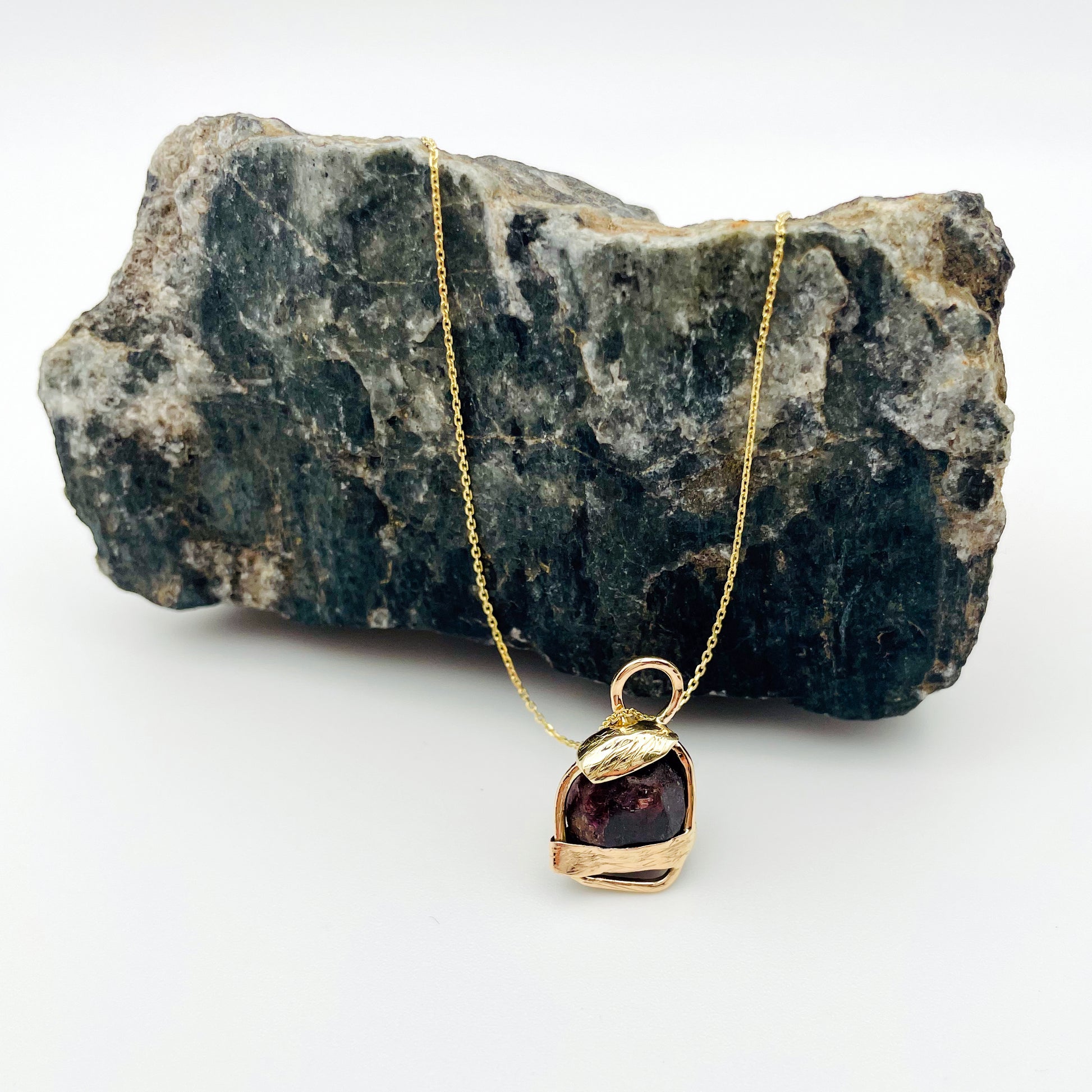 The Expanded Skies Raw Garnet Engraved Pendant has a beautiful raw Norwegian garnet set in 9ct gold. Handcrafted on the edge of Dartmoor and made from high quality recycled gold, Hallmarked by the London Assay Office. The garnet is housed in gold gateway, understated and beautiful, it can be worn every day or for special occasions. This is a unique piece, one-of-a-kind.