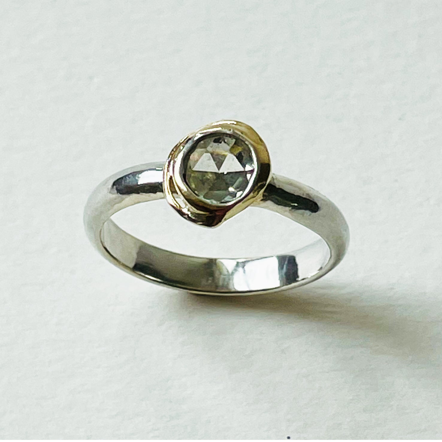 Haytor Quarry Pool White Sapphire Ring has a beautiful ethically sourced Sri Lankan faceted white 5mm sapphire, set in 9ct gold, on sterling silver band. Completely handcrafted from high quality recycled sterling silver and recycled gold. Understated and beautiful, it can be worn every day and for special occasions.