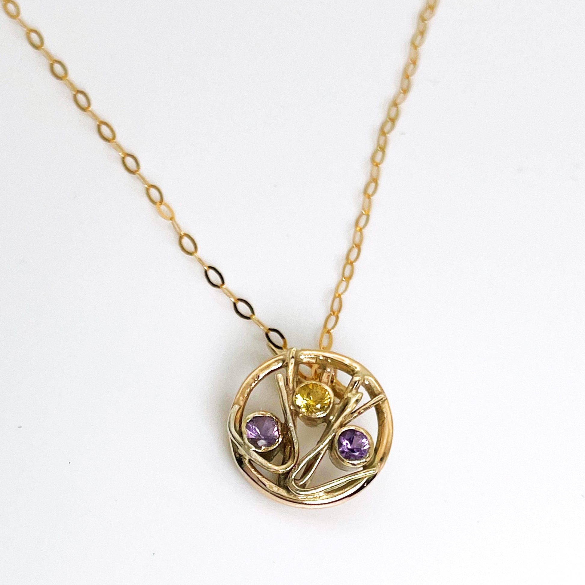 The Expanded Skies Dartmoor Heather and Gorse Pendant evokes the beautiful yellows of the gorse and purples of the heather with an ethically sourced yellow sapphire and two amethysts held in twisting branches of 9ct yellow gold. The pendant comes with a 9ct gold chain, a choice of lengths are available.
This handcrafted unique, one-off, piece makes a wonderful gift, celebrating the evocative and joyful colours of Dartmoor.