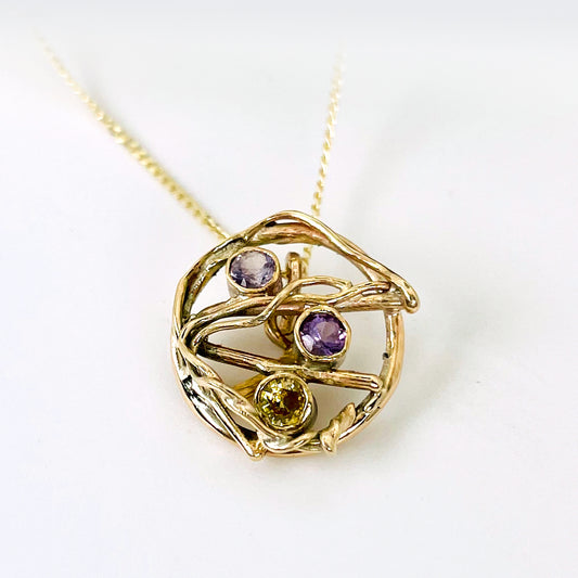 The Expanded Skies Haytor Heather and Gorse Amethyst and Sapphire Pendant evokes the beautiful yellows of the gorse and purples of the heather with an ethically sourced yellow sapphire and two amethysts held in twisting branches of 9ct yellow gold. The pendant comes with a 9ct gold chain, a choice of lengths are available.