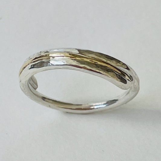 The Dartmoor Dart Valley Hammered Ring, inlaid with 9ct Gold, is inspired by the River Dart, that viewed from high on top of granite moorland, glints and snakes through the steep sides of the deeply wooded valley.  The hammered band is handcrafted from a single band of sold sterling recycled silver at back that flows into a recycled 9ct gold band at the front, flanked by two silver bands.  Wear everyday, perfect as a wedding ring or to accompany any outfit, understated, beautiful.