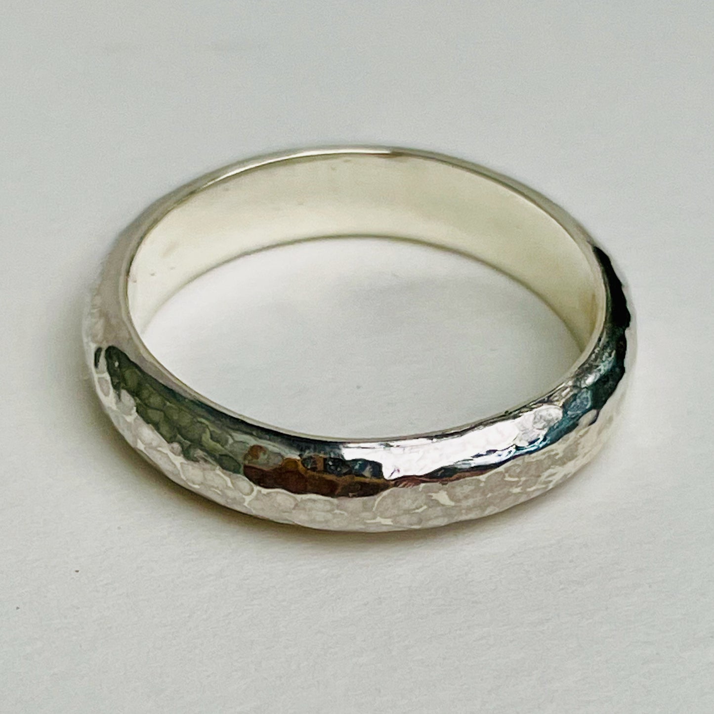 The Dartmoor Wide Hammered Ring is inspired by the sculptural beauty of the granite moorland. The hammered polished finish reflects the light beautifully. The band is handcrafted from sold sterling recycled silver. Suits everyone.