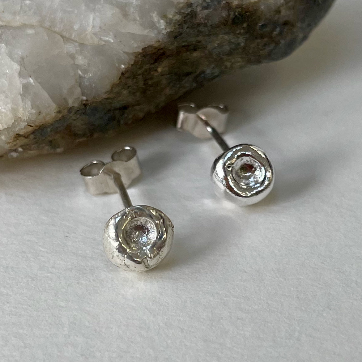 Inspired by the sculptural beauty of the Dartmoor granite rocks. The Dartmoor Rocks Studs are handcrafted in recycled fine silver with recycled sterling silver ear pins and scrolls, each stud is unique. Simple and elegant with a textured finish, and a polished finish they can be worn everyday for any occasion.