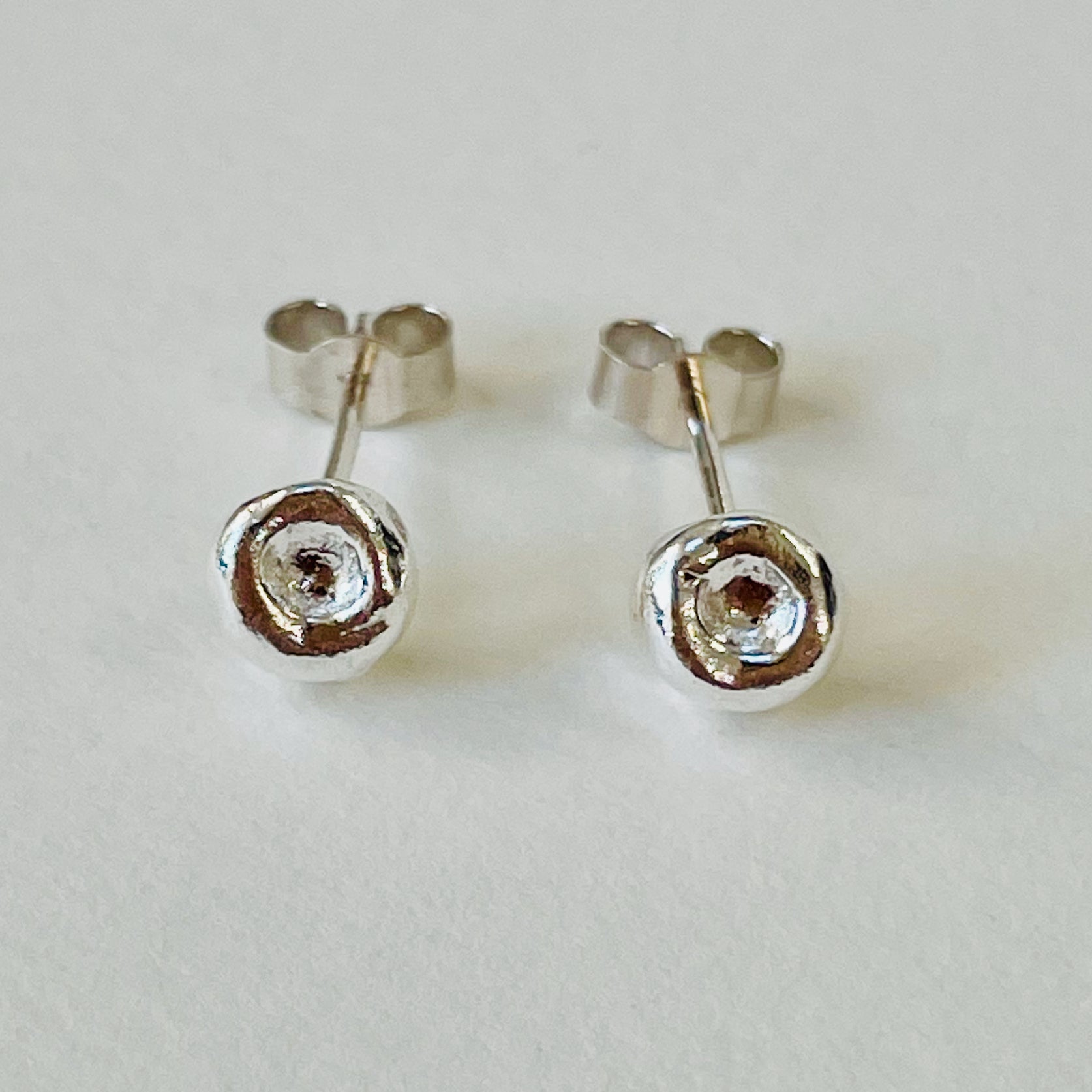 Inspired by the sculptural beauty of the Dartmoor granite rocks. The Dartmoor Rocks Studs are handcrafted in recycled fine silver with recycled sterling silver ear pins and scrolls, each stud is unique. Simple and elegant with a textured finish, and a polished finish they can be worn everyday for any occasion.