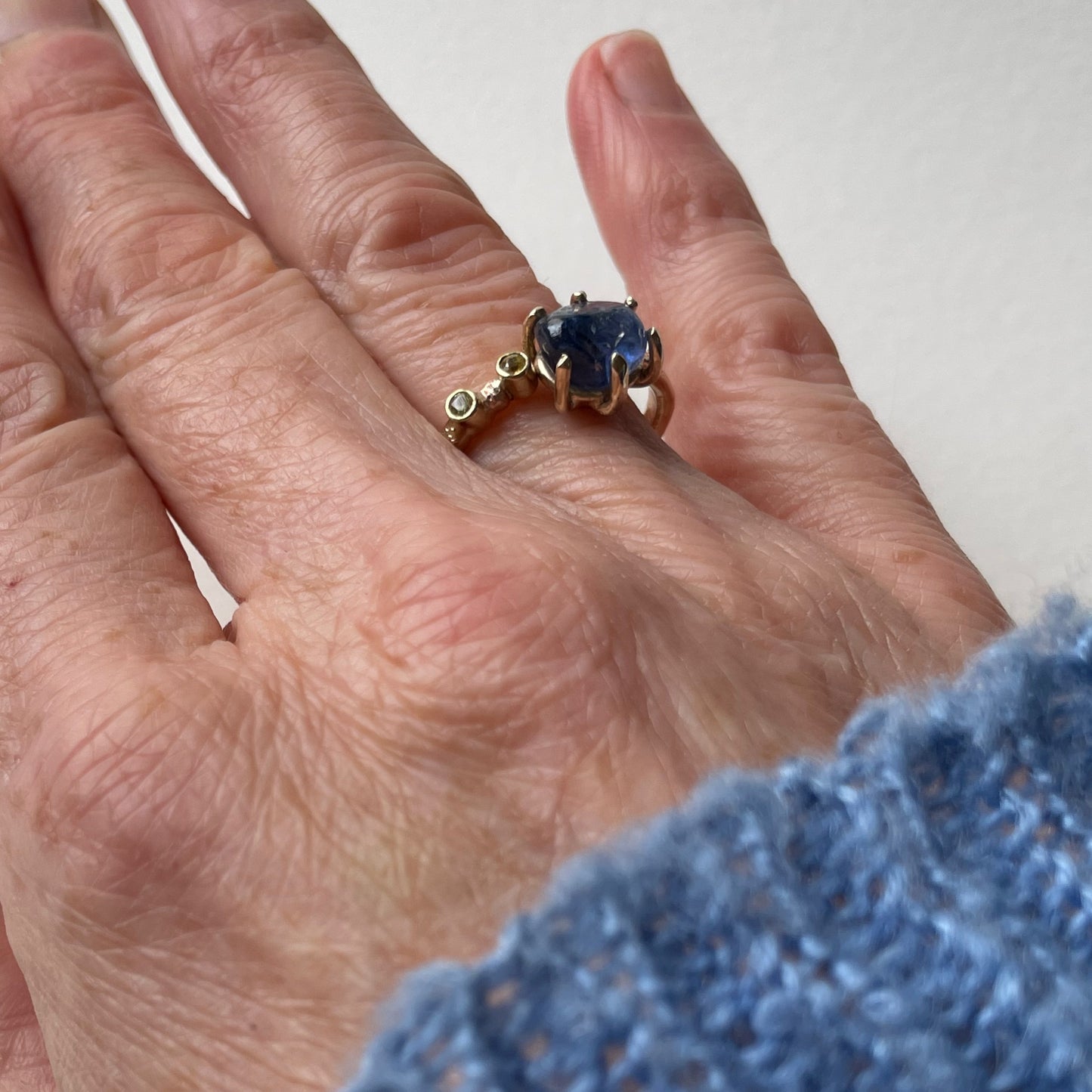 The Dartmoor Sun and Skies Sapphire Ring reflects the big Dartmoor skies, the contrasting colours and textures of the moving light over the landscape, created with ethically sourced raw and facetted sapphires and different shades of gold.