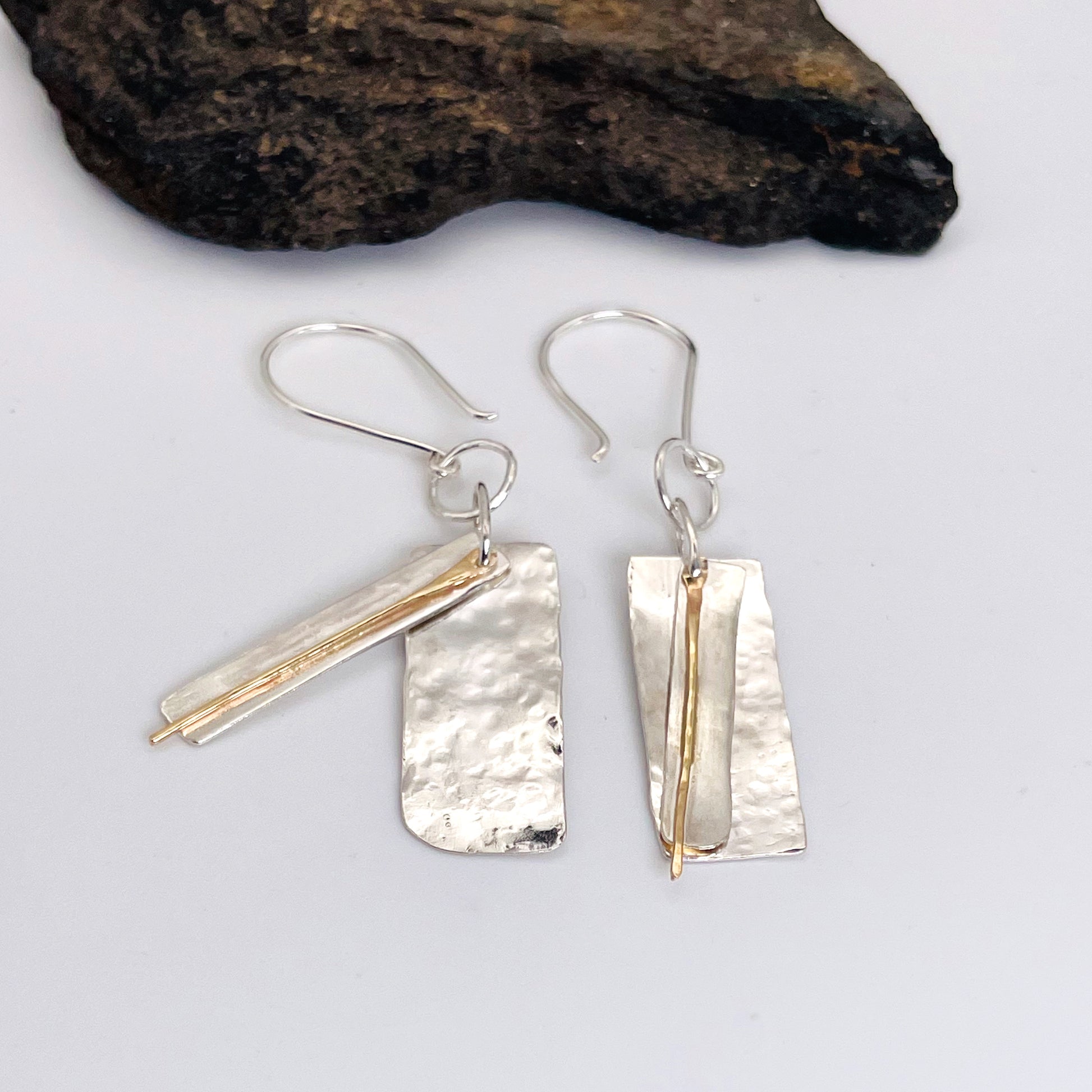 The Dartmoor Dart Valley earrings, are inspired by the River Dart, that viewed from high on top of granite moorland, glints and snakes through the steep sides of the deeply wooded valley.  Handcrafted layers of solid recycled sterling silver are hammered and polished with a fine 9ct gold bar, that swing and catch the light.