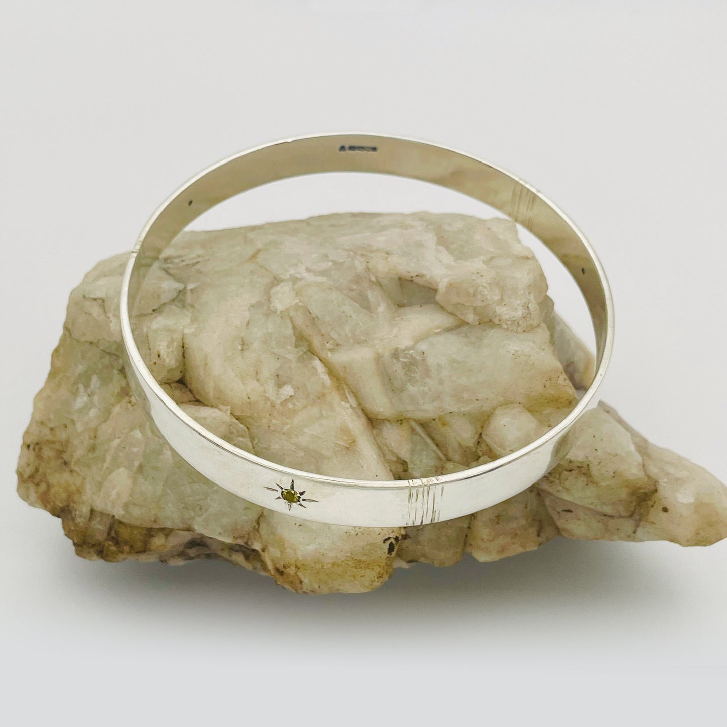 Expanded Skies Yellow Sapphire Star Set Bangle evokes the stars that shine bright in the dark skies on Dartmoor.

Three yellow Sri Lankan sapphires are star set with hand engraved rays in the signature hand-drawn aesthetic. The bangle is totally handcrafted on the edge of Dartmoor in high quality recycled sterling silver. For men and women, simple, beautiful.