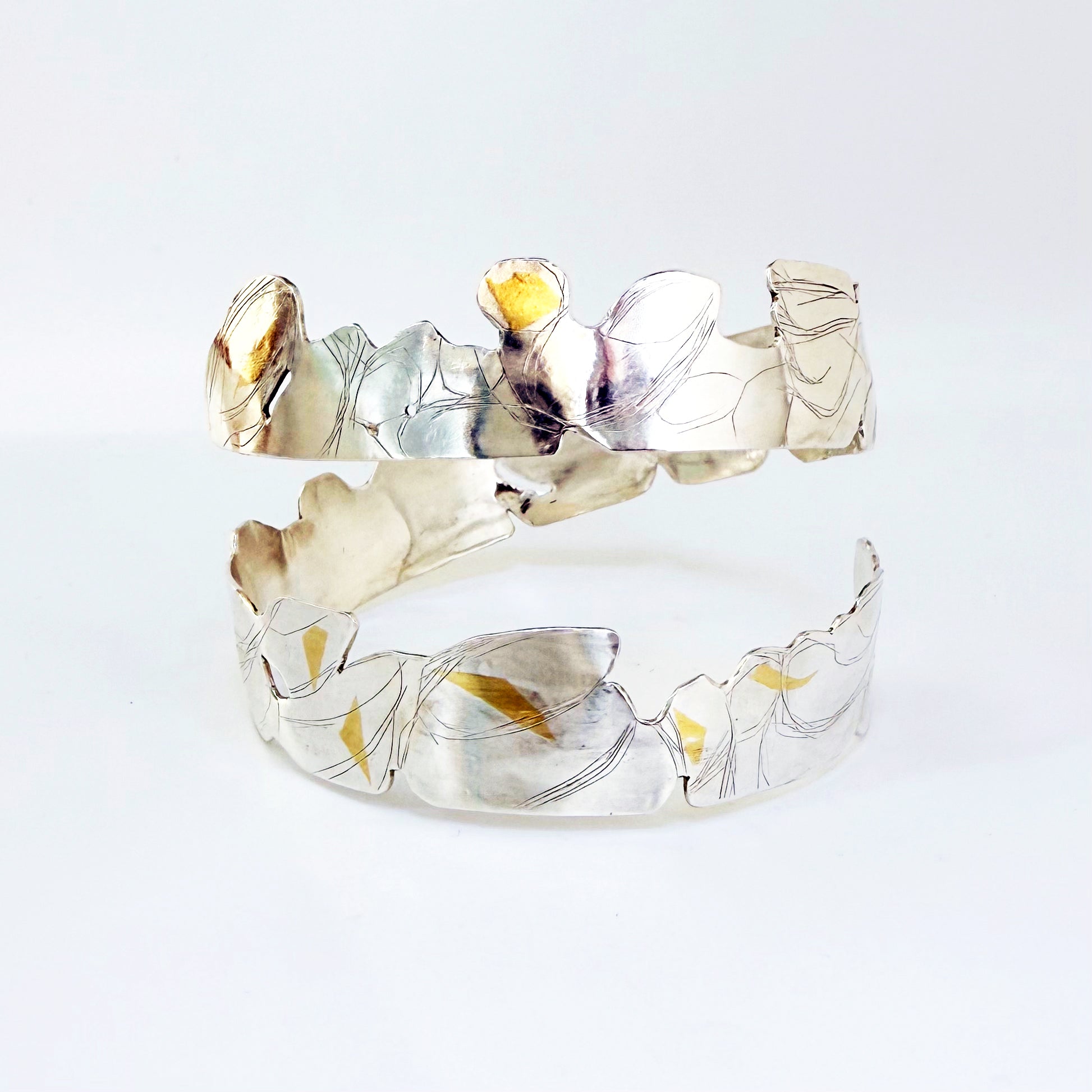 Expanded Skies Bone Tor Bangle with 24ct Gold Accents is inspired by the contours and forms of Dartmoor’s Bone Tor, near Widdecombe on the Moor, at sunset. Fine silver with 24ct gold accents.