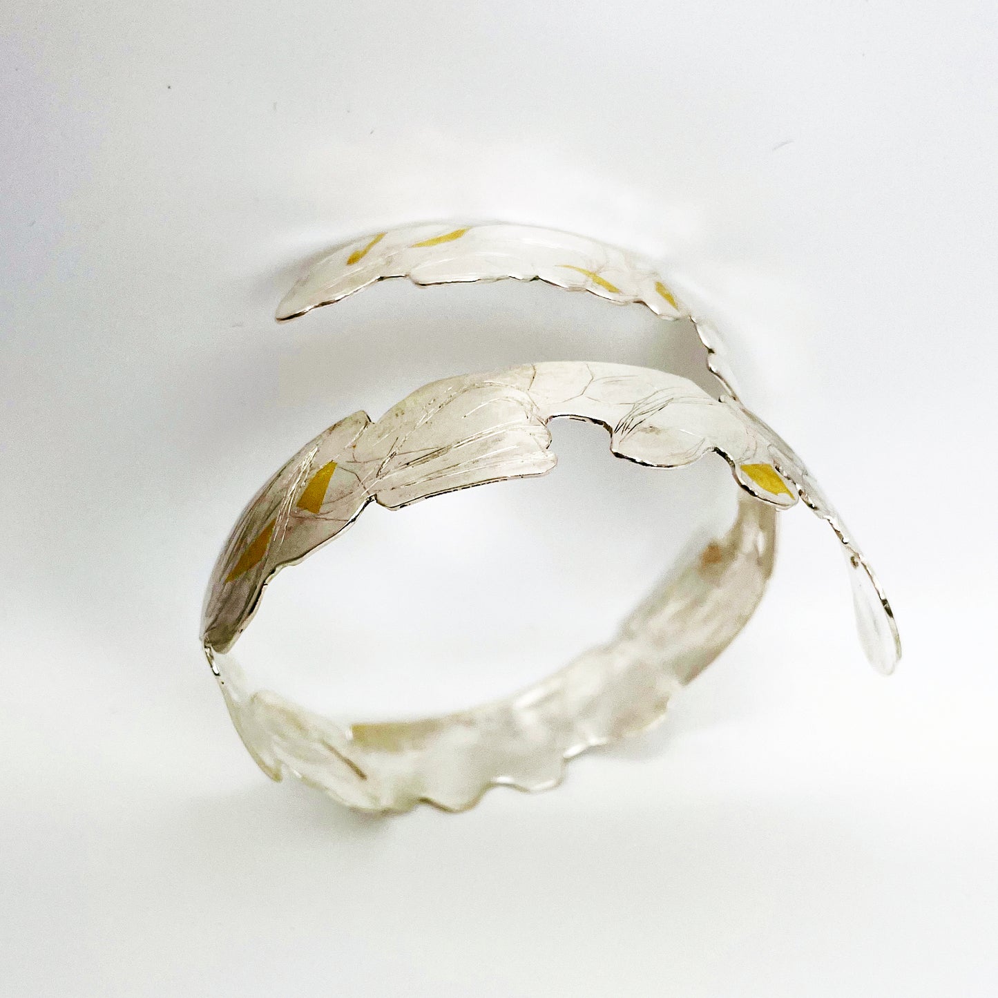Expanded Skies Bone Tor Bangle with 24ct Gold Accents is inspired by the contours and forms of Dartmoor’s Bone Tor, near Widdecombe on the Moor, at sunset. Fine silver with 24ct gold accents.
