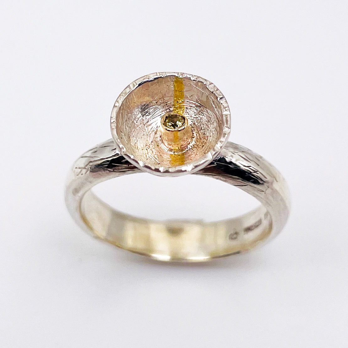 Expanded Skies Capella Star Ring is inspired by the dark Dartmoor skies and yellow Capella Star. Created with hand engraving and gold accents and a beautiful Sri Lankan, ethically sourced, yellow sapphire. Drawn with hand engraving and set with a twinkling yellow faceted sapphire in 9ct gold and fine silver.