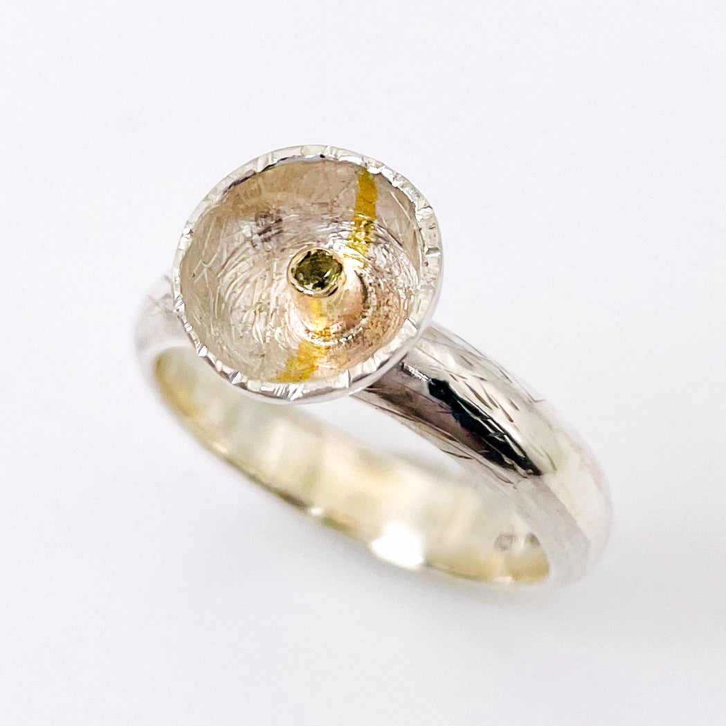 Expanded Skies Capella Star Ring is inspired by the dark Dartmoor skies and yellow Capella Star. Created with hand engraving and gold accents and a beautiful Sri Lankan, ethically sourced, yellow sapphire. Drawn with hand engraving and set with a twinkling yellow faceted sapphire in 9ct gold and fine silver.