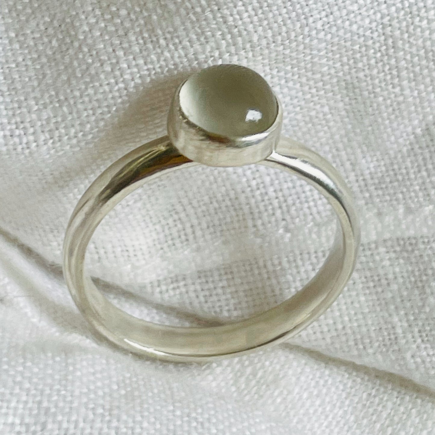 The Full Moon Moonstone Ring has a tranquil beauty of the light of the full moon reflected on a still pool. Totally handcrafted, it features an ethically mined moonstone from Sri Lanka set in quality 100% recycled sterling silver. 