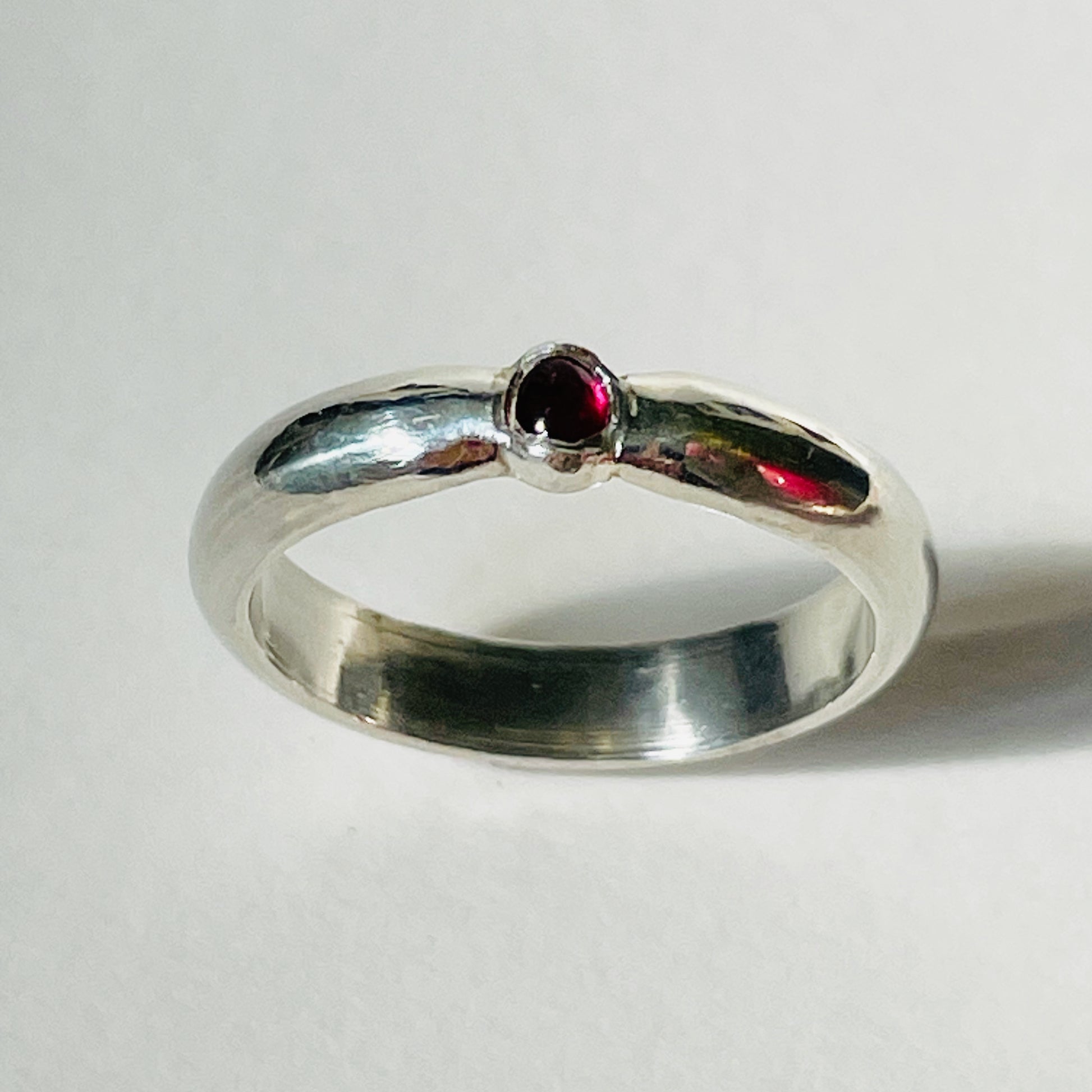 The Ruby-Joy Ring is has a hint of the 1950's exuberance of pinched waists and wide skirts, with a tapering silver band that clasps the oval lustrous pink-red ethically sourced Greenland ruby. With a timeless elegance that can be worn everyday or for special occasions.  Dimensions:  2mm D-shaped recycled sterling silver band 4mm x 3mm approx Ethically Mined Greenland Ruby