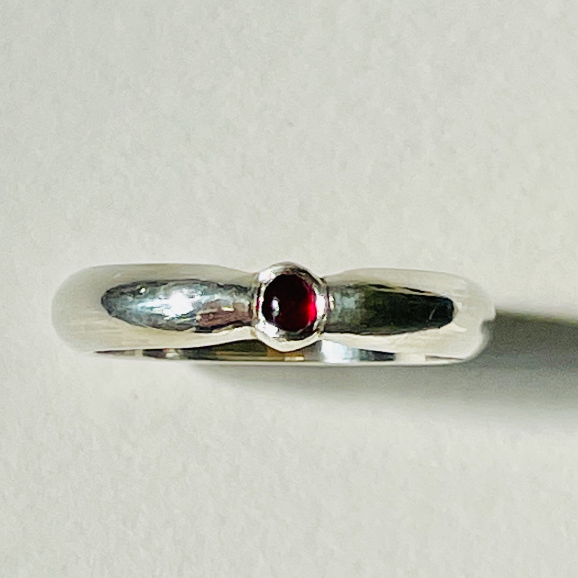 The Ruby-Joy Ring is has a hint of the 1950's exuberance of pinched waists and wide skirts, with a tapering silver band that clasps the oval lustrous pink-red ethically sourced Greenland ruby. With a timeless elegance that can be worn everyday or for special occasions.  Dimensions:  2mm D-shaped recycled sterling silver band 4mm x 3mm approx Ethically Mined Greenland Ruby