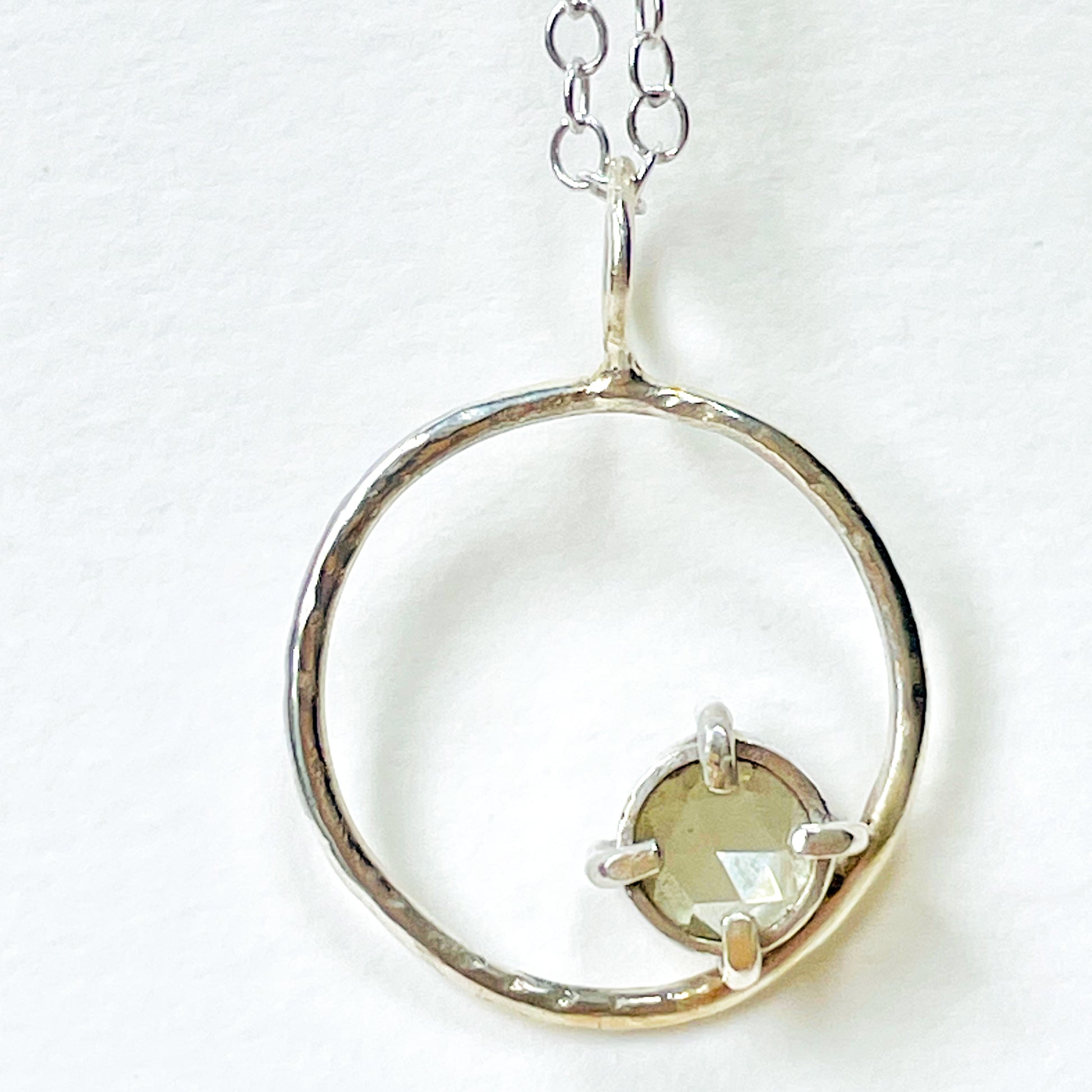 The Moon Light White Sapphire pendant sparkles as its facets reflects the light. The beautiful 5mm rose cut ethically mined Sri Lankan white sapphire has a handcrafted four claw setting on a hammered silver sterling silver band. Understated and beautiful, it can be worn everyday or for special occasions. The pendant comes with a 1.7mm recycled sterling silver trace chain