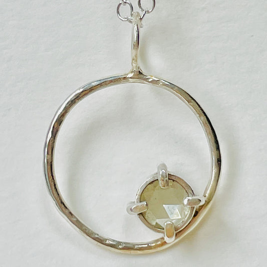 The Moon Light White Sapphire pendant sparkles as its facets reflects the light. The beautiful 5mm rose cut ethically mined Sri Lankan white sapphire has a handcrafted four claw setting on a hammered silver sterling silver band. Understated and beautiful, it can be worn everyday or for special occasions. The pendant comes with a 1.7mm recycled sterling silver trace chain
