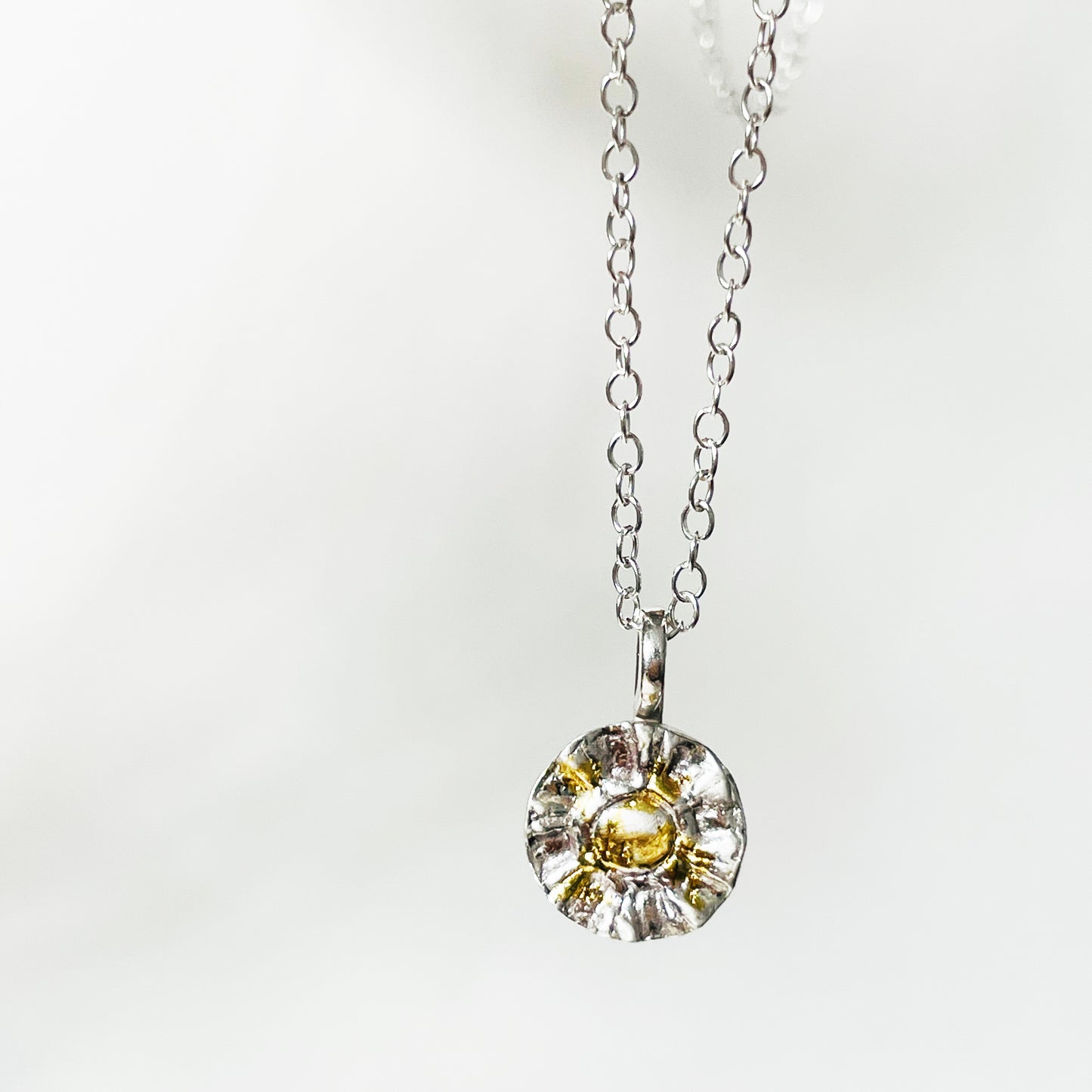 The Radiant Sun Pendant with 22ct gold is joyful! Hand sculpted in recycled solid fine silver (999) with a textured surface and a twinkly beauty all of its own. 22ct heavy gold foil is applied using a traditional Korean gilding technique that makes each piece unique.