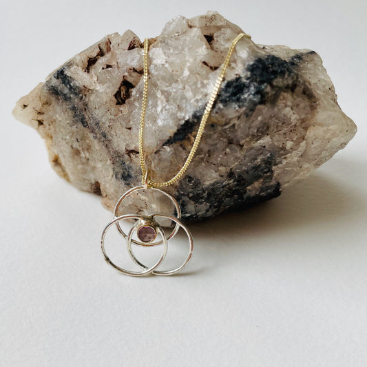 Expanded Skies Sapphire Harmony and Balance Pendant has a beautiful ethically sourced Sri Lankan delicate pink faceted sapphire set in 9ct gold, on three sterling silver textured rings. Made from high quality recycled sterling silver and gold. Understated and beautiful, it can be worn every day or for special occasions.